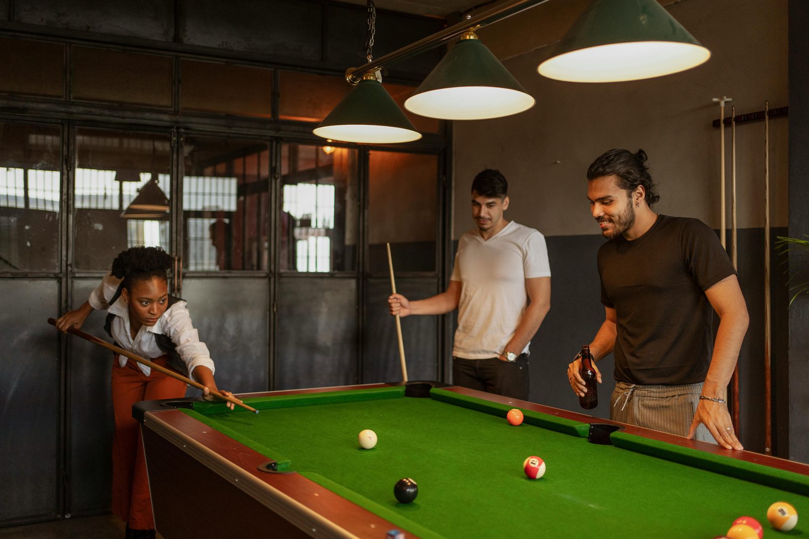 Friends playing pool together in a billiards room